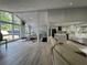 Bright and airy living room open to kitchen and dining area with large windows and wood flooring at 453 James Street Sw, Lilburn, GA 30047