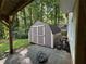 Exterior shed with double doors is located in backyard with trees offering privacy at 453 James Street Sw, Lilburn, GA 30047