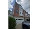 Exterior elevation of a townhome with brick and siding, featuring an attached garage at 1346 Pilgrim Lake Dr, Cumming, GA 30040