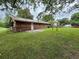 View of a backyard with a grassy lawn, a patio, mature trees, and partial fencing at 1932 Pharrs Rd, Snellville, GA 30078