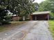 Modest one-story home featuring a brick facade, a large carport, and a driveway at 1932 Pharrs Rd, Snellville, GA 30078