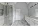 Bathroom with double vanity, glass enclosed shower, and gray wood-look tile floor at 5036 Weatherstone Drive, Buford, GA 30519