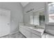 Bathroom featuring a long double vanity, large mirror, gray tile accent, and shower with glass door at 5036 Weatherstone Drive, Buford, GA 30519