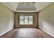 Bedroom with tray ceilings, large window, and hardwood floors at 5036 Weatherstone Drive, Buford, GA 30519