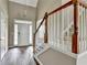 Bright foyer with wood floors, staircase and a view of the front door with transom window at 5036 Weatherstone Drive, Buford, GA 30519