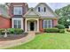 Inviting front entrance of a brick home with a manicured lawn and pathway to the front door at 5036 Weatherstone Drive, Buford, GA 30519