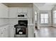 Close up of a kitchen featuring a range and microwave with white cabinets and wood floors at 5036 Weatherstone Drive, Buford, GA 30519