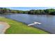 Scenic view of the lake with a new dock on the grassy shoreline—perfect for enjoying lakeside living at 5036 Weatherstone Drive, Buford, GA 30519