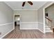 Inviting living room featuring hardwood floors, crown molding and a glimpse of the kitchen and staircase at 5036 Weatherstone Drive, Buford, GA 30519
