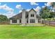 Well-maintained rear exterior featuring a spacious lawn, concrete patio, and wooden fence at 5036 Weatherstone Drive, Buford, GA 30519