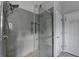 Glass enclosed shower with gray tile, stone floor, and chrome shower head at 5036 Weatherstone Drive, Buford, GA 30519