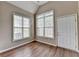 Bright sunroom featuring two windows and a white door, complimented by wood-look floors at 5036 Weatherstone Drive, Buford, GA 30519