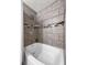 Relaxing bathtub with tiled surround and shower features a mosaic tile accent at 610 Lake Dr, Snellville, GA 30039