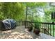 Outdoor deck area with a grill, plants, and a view of lush greenery at 610 Lake Dr, Snellville, GA 30039