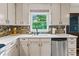 Bright kitchen sink area with a garden window and stainless steel dishwasher at 610 Lake Dr, Snellville, GA 30039