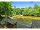 Lake view from the wooden dock, featuring mature trees and calm water at 610 Lake Dr, Snellville, GA 30039