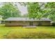 Back exterior of a single story home with a brick facade and a small patio at 1496 Indian Forest Ct, Stone Mountain, GA 30083