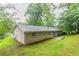Backyard view of a brick house with a patio and mature trees at 1496 Indian Forest Ct, Stone Mountain, GA 30083