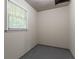 An unfinished basement features a window and grey painted floor at 1496 Indian Forest Ct, Stone Mountain, GA 30083