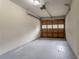 An empty garage with a gray concrete floor and a wooden garage door with glass panels at 1496 Indian Forest Ct, Stone Mountain, GA 30083