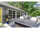 Back deck with an outdoor table and cushioned chairs overlooking the greenery and tree line at 2730 Samples Rd, Cumming, GA 30041