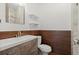 Bathroom featuring tile accent wall, updated fixtures, and wood-look flooring at 2730 Samples Rd, Cumming, GA 30041