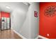 Bright hallway features hardwood floors, stainless steel refrigerator and pops of vibrant red color at 2730 Samples Rd, Cumming, GA 30041