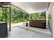 Covered hot tub on the patio with a serene view of the lush green backyard and surrounding trees at 2730 Samples Rd, Cumming, GA 30041