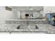 Granite countertop and stainless sink with view into the living area of this open concept home at 2730 Samples Rd, Cumming, GA 30041