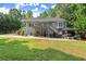 Backyard view of home with deck, patio, gazebo, and hot tub surrounded by lush greenery and lawn at 2730 Samples Rd, Cumming, GA 30041
