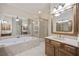 This bathroom includes a soaking tub, walk-in shower, and vanity with a large mirror at 4742 Legacy Cove Ln, Smyrna, GA 30126