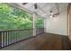 Covered porch with ceiling fans, dark stained wood floors, and wooded view at 4742 Legacy Cove Ln, Smyrna, GA 30126