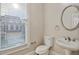 Powder room featuring a pedestal sink, oval mirror, toilet, and a window at 4742 Legacy Cove Ln, Smyrna, GA 30126