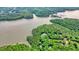 Picturesque aerial view of a lakefront property surrounded by lush greenery and tranquil waters at 627 Apache Trl, Woodstock, GA 30189