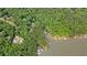 Picturesque aerial view showcasing a beautiful lakefront property surrounded by dense, green trees and waterfront docks at 627 Apache Trl, Woodstock, GA 30189