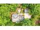 Aerial view of a home featuring a fire pit and a long driveway surrounded by trees with lush greenery at 627 Apache Trl, Woodstock, GA 30189