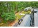 Aerial view of backyard featuring a fire pit, deck with grill, mature trees and a cozy outdoor space at 627 Apache Trl, Woodstock, GA 30189