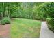 Expansive backyard with lush green lawn and mature trees for privacy at 627 Apache Trl, Woodstock, GA 30189