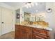 Bathroom with stone countertops, dual sinks, a large mirror, and a walk-in shower with glass doors at 627 Apache Trl, Woodstock, GA 30189
