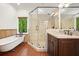 Bathroom featuring double sinks, granite counters, glass shower, and clawfoot tub at 627 Apache Trl, Woodstock, GA 30189