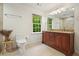 Bright bathroom featuring a wood vanity with granite countertops, large mirror, and a window offering a view of the outdoors at 627 Apache Trl, Woodstock, GA 30189