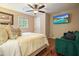 Comfortable bedroom with a plush bed, hardwood floors, and a mounted television at 627 Apache Trl, Woodstock, GA 30189