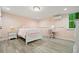 Bright bedroom design with pink walls, hardwood flooring, vanity, and natural light at 627 Apache Trl, Woodstock, GA 30189