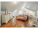 Bonus room featuring hardwood floors, a plush pink sofa, complemented by stylish decor and ample natural light at 627 Apache Trl, Woodstock, GA 30189