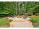 An outdoor firepit surrounded by a stone patio and seating for a cozy backyard experience at 627 Apache Trl, Woodstock, GA 30189