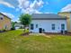 Back exterior of house overlooking the lawn with a small patio, and an air conditioning unit near the back door at 2077 Appaloosa Way Way, Conyers, GA 30012