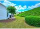 A sloped, grassy backyard featuring mature trees and lush landscaping creates a peaceful, private setting at 2077 Appaloosa Way Way, Conyers, GA 30012