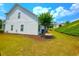 A sloped, grassy backyard featuring mature trees and lush landscaping creates a peaceful, private setting at 2077 Appaloosa Way Way, Conyers, GA 30012
