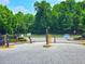 View of the gated entrance to the residential community with mature trees and landscaping at 2077 Appaloosa Way Way, Conyers, GA 30012