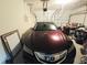 Car parked inside a garage with an open overhead door and various stored items at 2077 Appaloosa Way Way, Conyers, GA 30012